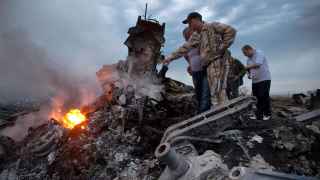 Люди осматривают место крушения самолета MH17 в Грабово, Украина, 17 июля 2014 г.   