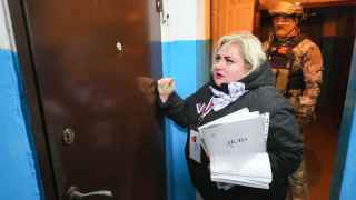 Сотрудник избирательной комиссии собирает голоса по квартирам в оккупированном Донецке